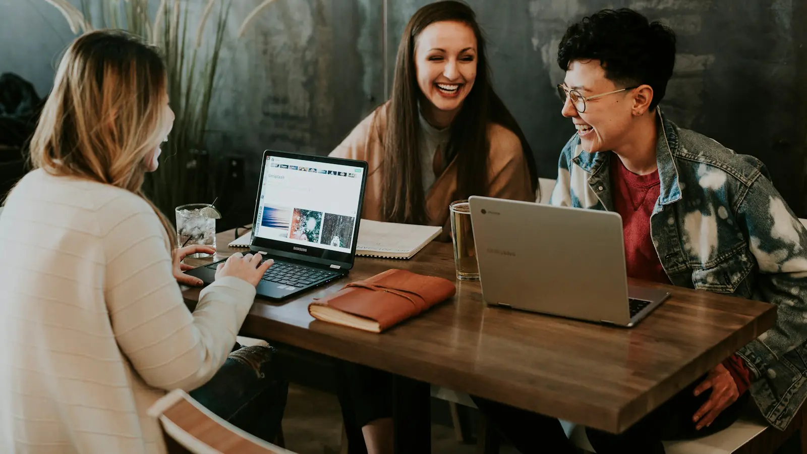 AI tools at work — three people sitting in front of table laughing together