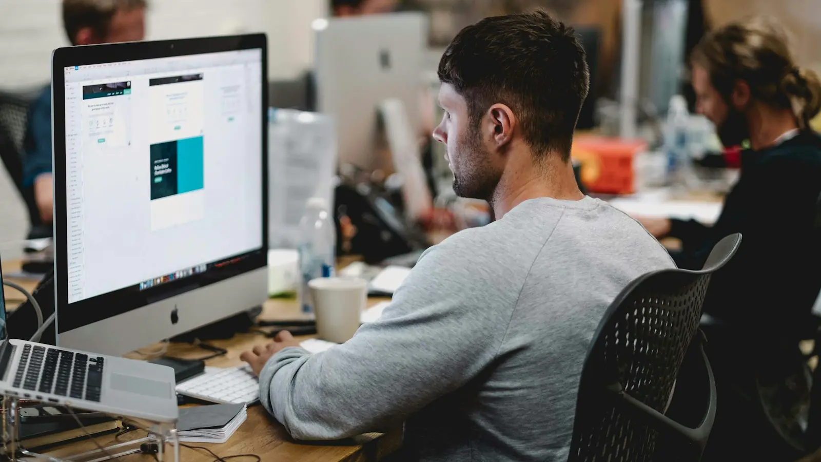 DIY AI automation mistakes — man in gray sweatshirt sitting on chair in front of iMac